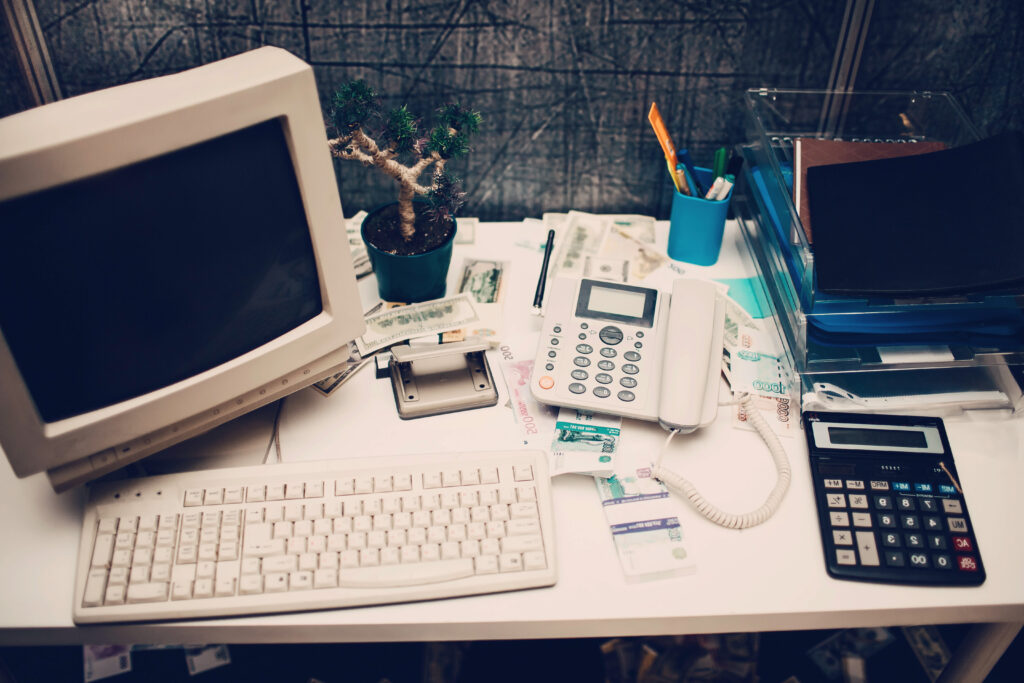A photograph of a retro personal computer on a cluttered office desk.