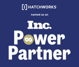 An image with a blue background displaying the text '[i] HATCHWORKS™ named as an Inc. Power Partner' with the Inc. logo and a gold circular emblem in the center.