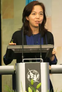 Woman speaking at a podium with ITU logo.